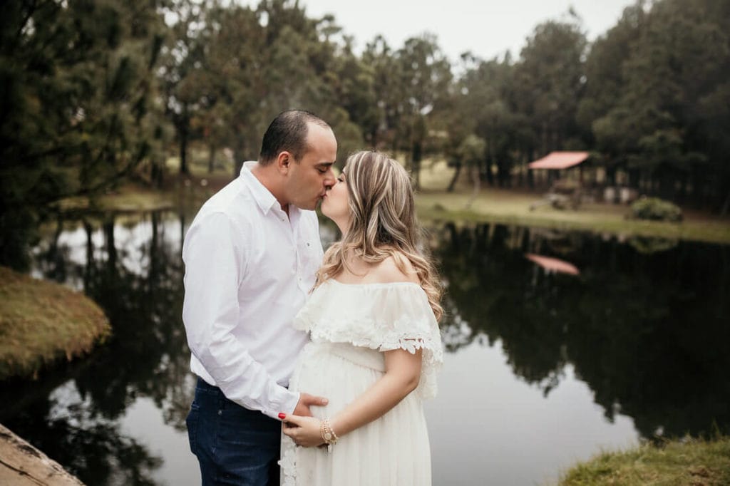 Hombre besando a su esposa en su sesión de fotos de embarazo.