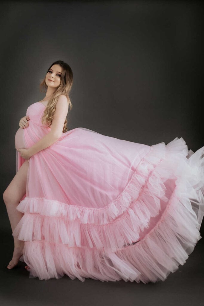 Mujer embarazada con vestido hermoso posando en su sesión de fotografías.